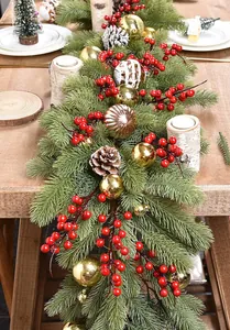 Detail of Christmas PE garland with red berries, gold ornaments, and snow-dusted pine cones