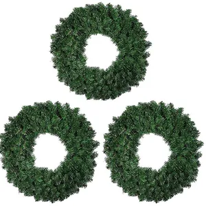 Three deep green artificial pine needle Christmas wreaths set against a white background