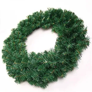Close-up of artificial green PVC Christmas wreath with dense needles on white background