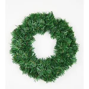 Classic green artificial PVC Christmas wreath with dense foliage on white background