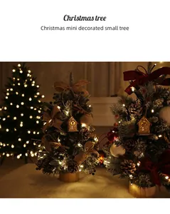 Dettaglio di un mini albero di Natale innevato con luci LED e casetta XMAS
