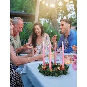 Christmas candle holder wreath with red berries, pine needles, and pink candles for table