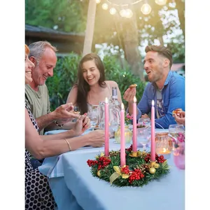 Portacandele natalizio con candele rosa e ghirlanda di bacche per decorazione tavola