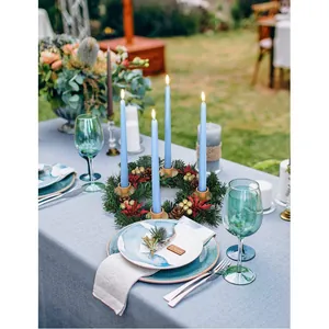 Christmas pine wreath candle holder with red berries and four blue taper candles
