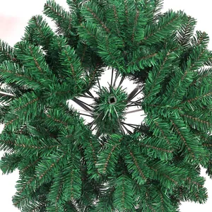 Dense green PVC artificial Christmas tree section showing realistic pine needle texture
