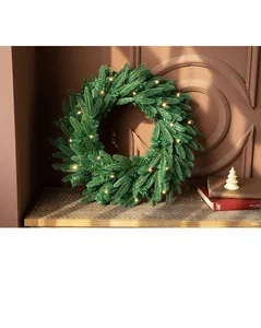 Dettaglio ghirlanda di Natale in pino artificiale con luci LED bianche calde su legno