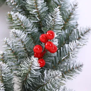 Christmas wreath branch with snow-covered pine needles and bright red berries decor
