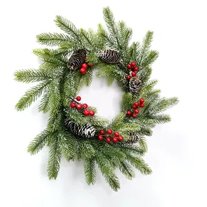 Detailed close-up of PE pine needles with red berries and snowy pinecones on festive wreath