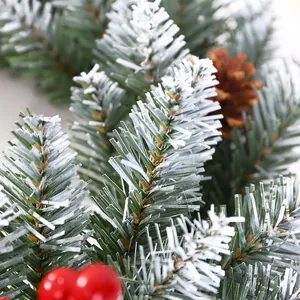 Christmas wreath with frosted pine needles, natural pine cones and red berries decoration