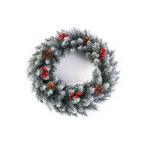 Christmas wreath with green pine needles, white flocking, red berries, and pine cones