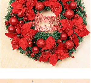 Detail eines grünen Weihnachtskranzes mit roten Weihnachtssternen und Merry Christmas Schild