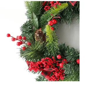 Close-up of Christmas wreath featuring red berries, pine cones and a buffalo plaid bow