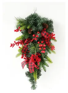 Close-up of Christmas teardrop swag with red berries, pine cones and buffalo plaid bow