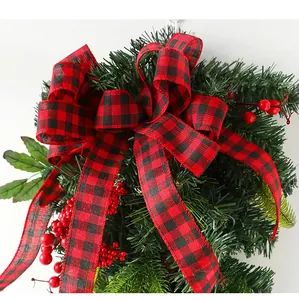 Detail of Christmas wreath with red berries, pine needles and buffalo plaid bow decoration