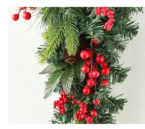 Detailed view of Christmas wreath featuring red berries, pine cones and artificial pine needles