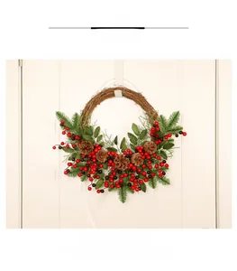 Detail of Christmas wreath with pine cones and red berries on a cream-colored door
