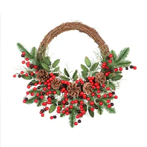 Christmas wreath with green pine needles, red berries and pine cones on rattan base