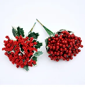 Detalle de tallos de bayas rojas artificiales con hojas para decoración navideña