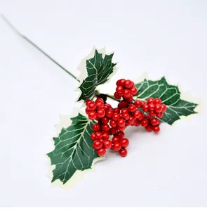 Detalle de bayas rojas artificiales con hojas verdes para decoraciones navideñas