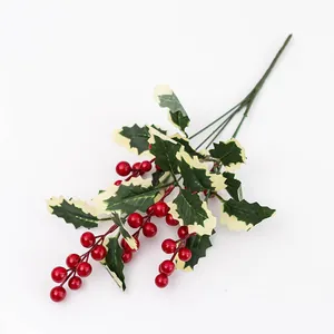 Detalle de bayas rojas de acebo artificiales con hojas verdes para decoración de Navidad