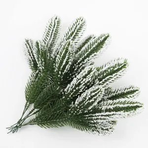 Detailed view of artificial frosted pine branches with realistic white snow flocking effect