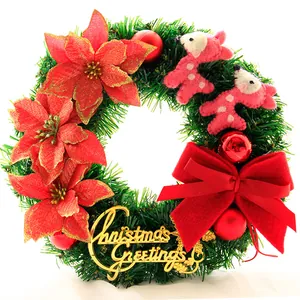 Detail eines Weihnachtskranzes mit Weihnachtssternen, Filzpuppen und einer roten Schleife