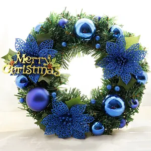 Macro detail of Christmas wreath featuring blue ornaments and golden Merry Christmas sign