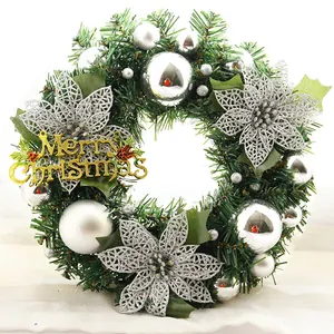 Close-up of Christmas wreath with silver poinsettias, ornaments and golden Merry Christmas sign