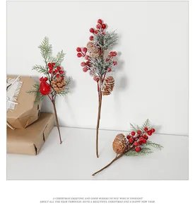 Close-up of red berries, pine cones, and cedar needles with artificial snow for Christmas