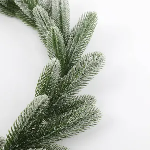 Macro detail of artificial pine branch with realistic snow frosting for Christmas decor