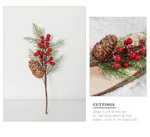 Macro detail of Christmas spray featuring red berries, pine cones and frosted pine needles