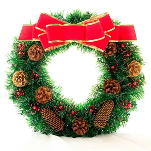 Detail eines Weihnachtskranzes mit Tannennadeln, Zapfen, roten Beeren und roter Schleife