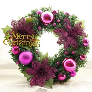 Close-up of Christmas wreath with purple ornaments and golden Merry Christmas sign