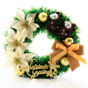Detail eines Weihnachtskranzes mit weißen Weihnachtssternen, goldenen Kugeln und Stoffbären