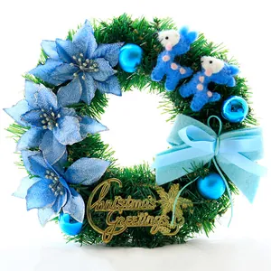 Detail eines blauen Weihnachtskranzes mit künstlichen Weihnachtssternen und Goldschild