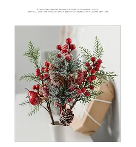 Close-up of artificial red berries and pine cones with faux snow for Christmas decor