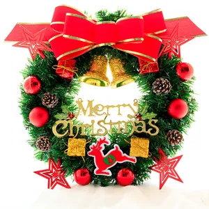 Detail eines Weihnachtskranzes mit roter Schleife, Zapfen, Goldglocken und Weihnachtsschild
