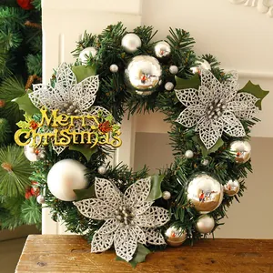 Detail of a green Christmas wreath with silver flowers and a gold Merry Christmas sign