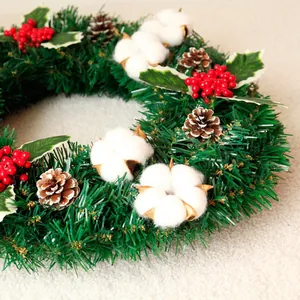 Weihnachtskranz mit grünen Kiefernnadeln, roten Beeren, Baumwolle und echten Kiefernzapfen
