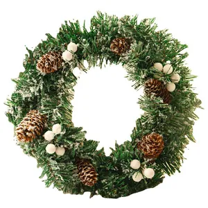 Christmas wreath with artificial pine needles, white berries, pine cones and snow flocking