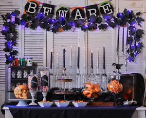 Macro shot of Halloween decor with black maple vines, purple LED lights, and skeleton props