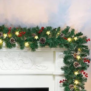 Green Christmas garland with pine cones, red berries and warm LED star lights