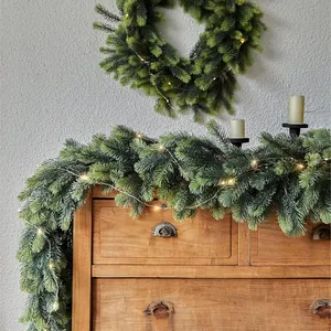 Artificial Christmas garland with pine needles and warm LED lights for festive home decor