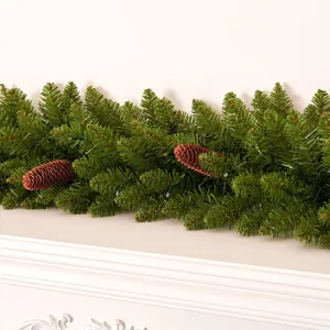 Christmas pine garland with natural cones and LED lights on a white fireplace mantel