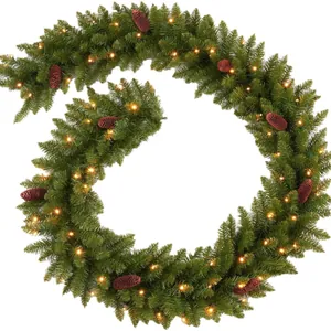 Green Christmas garland with pine cones and warm LED lights on a white background