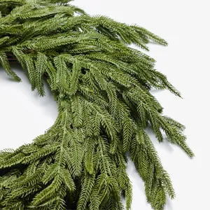Christmas pine needle wreath with natural green leaves and realistic wooden vine base