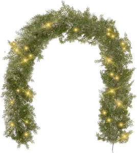 Detail of lush green artificial Christmas garland with warm yellow LED lights