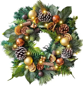 Detail of Christmas wreath with pine cones, dried orange slices and warm LED lights