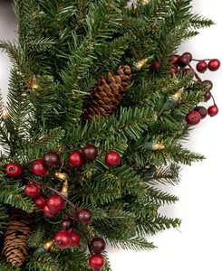 Detail eines Weihnachtskranzes mit Tannennadeln, Zapfen, roten Beeren und LED-Lichtern