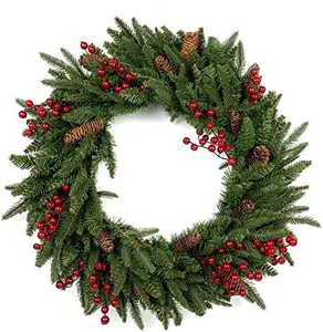 Detailansicht eines Weihnachtskranzes mit Kiefernnadeln, roten Beeren und echten Zapfen